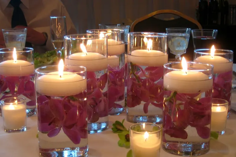 Floating candles in glass vases with pink petals, a wedding table centrepiece