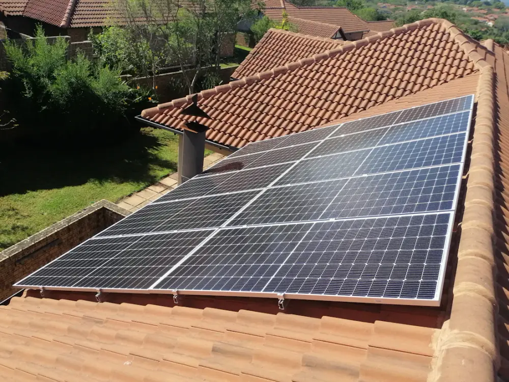 Solar panels on a tiled roof above a garden