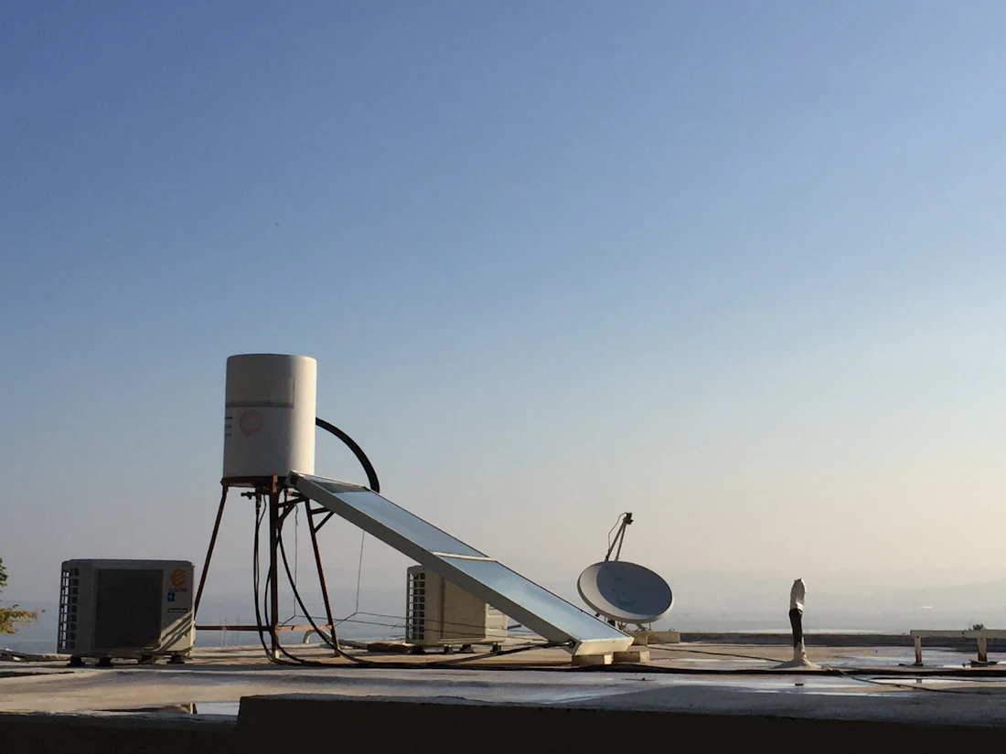 A solar water heater on a flat roof against the sky