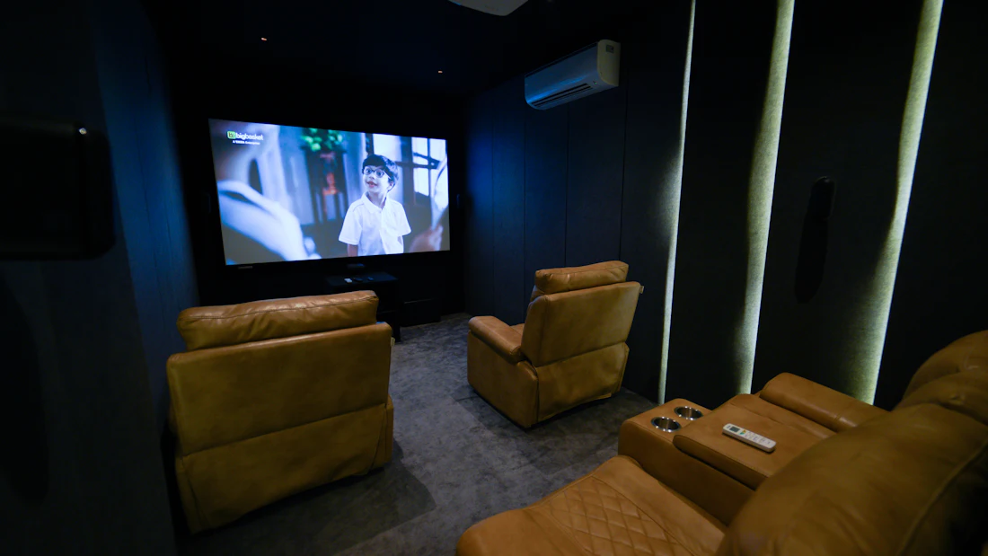 A small private cinema room with deep armchairs