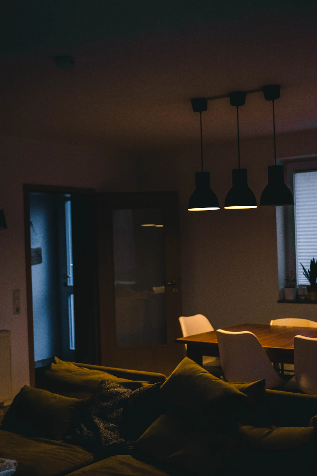 A kitchen with pendant lights at night