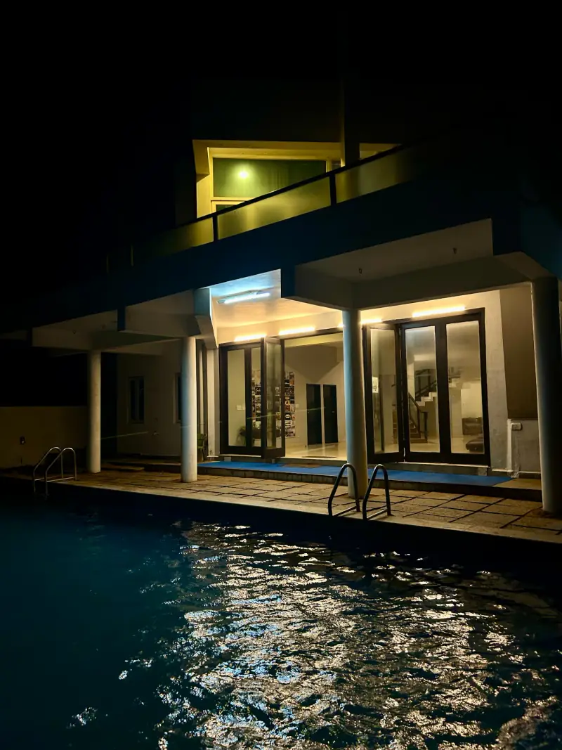 A modern villa and pool at night