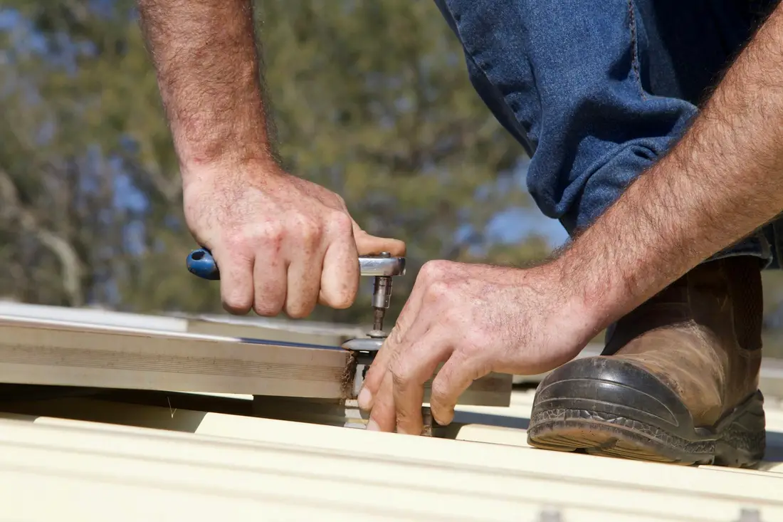 A roofer's hands fixing a roof
