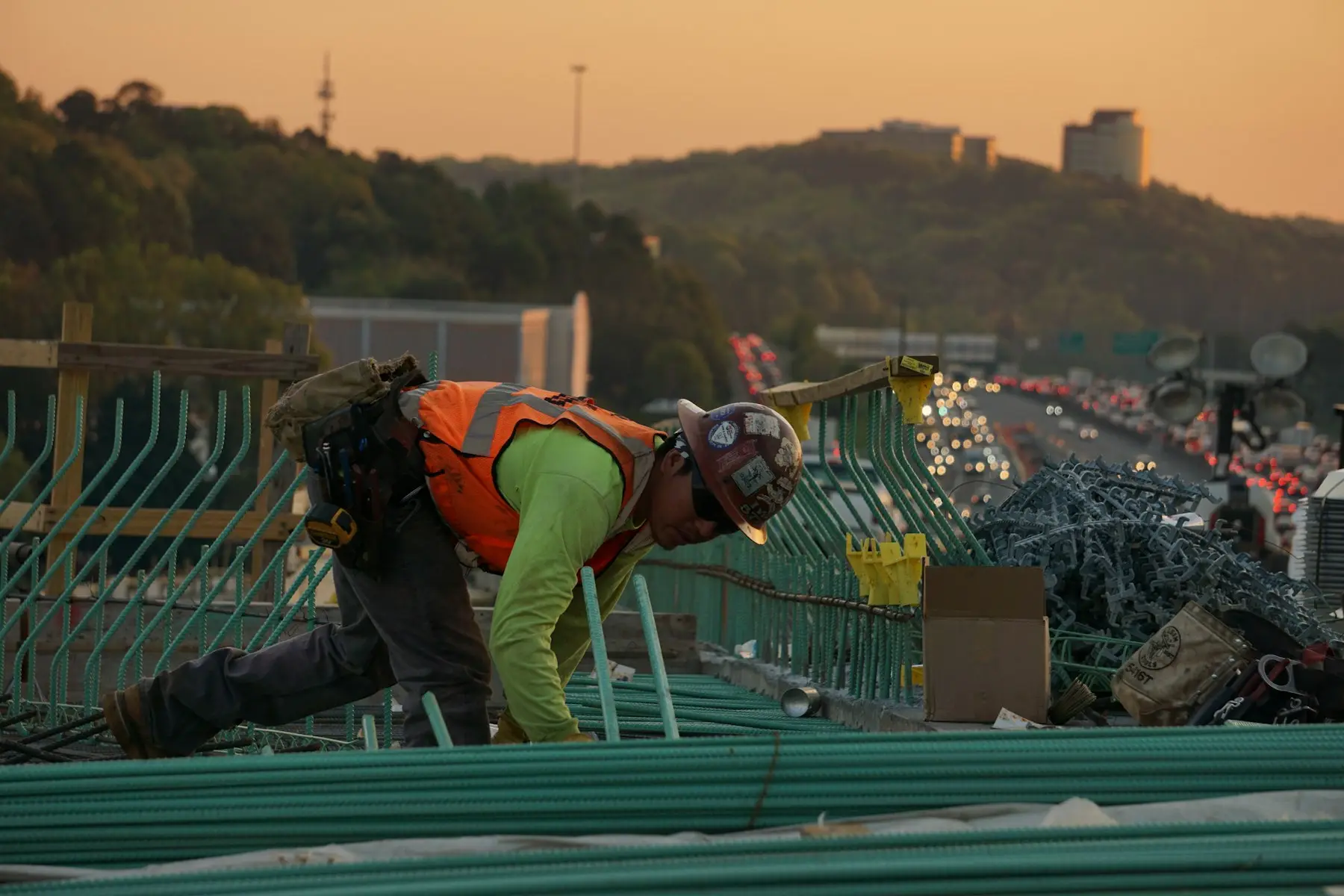 A roofer at work on a roof at sunset